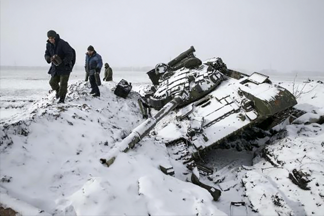 Members of the separatist self-proclaimed Donetsk People's Republic army collect parts of a destroyed Ukrainian army tank in the town of Vuhlehirsk, about 10 km (6 miles) to the west of Debaltseve, More... CREDIT: REUTERS/BAZ RATNER